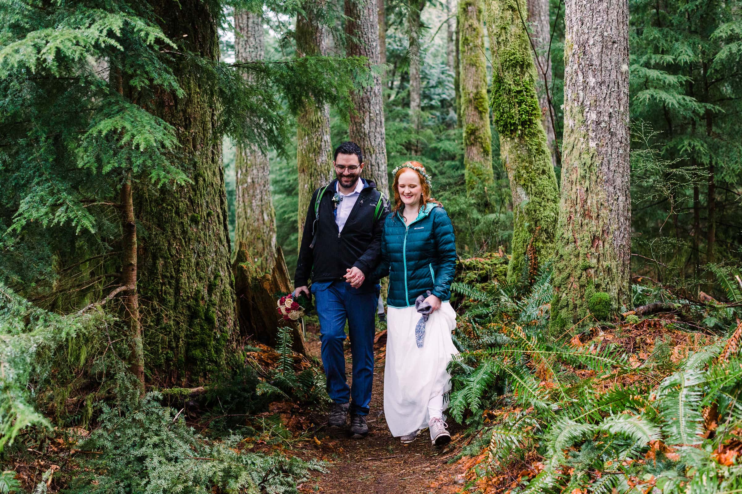 couple hiking in the forest wedding attire