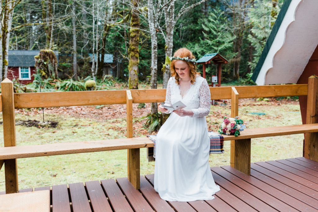 Bride reading her vows on the back porch of her cabin at her elopement.