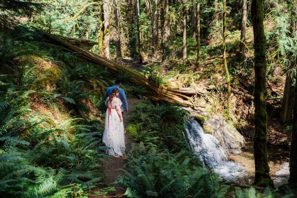 a couple exploring the top of a waterfall during their Orcacs Island Elopement