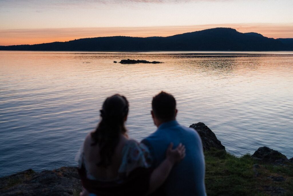 a couple enjoying an ocean sunset during their elopement.
