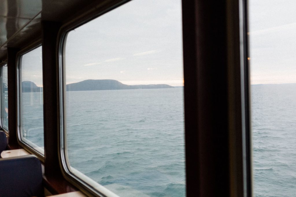 looking out of a ferry window at the puget sound islands