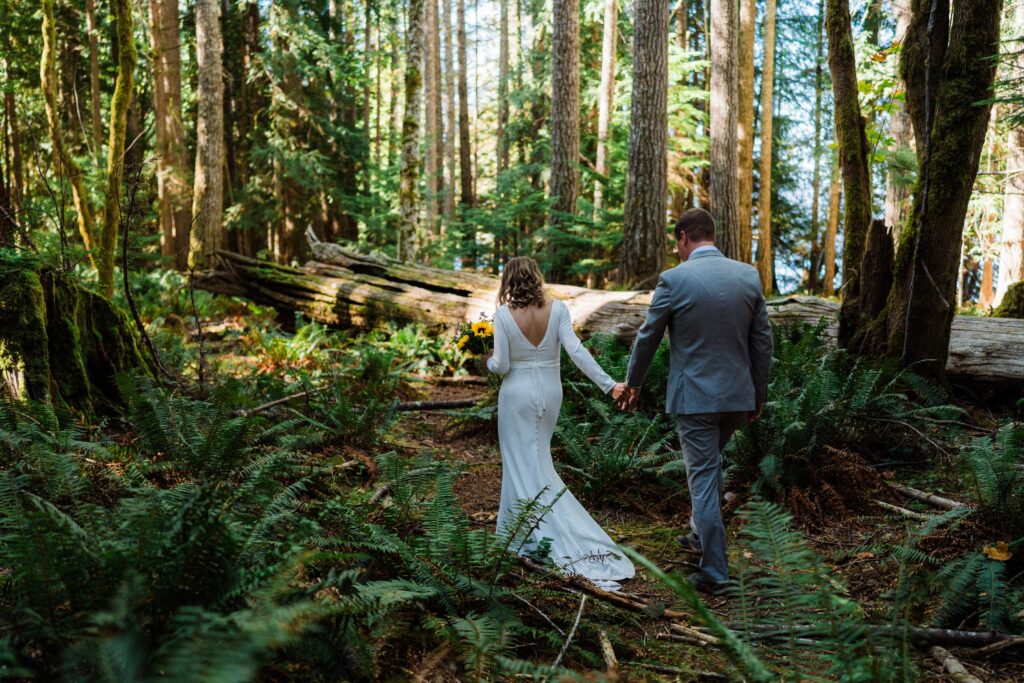 a bride leading her groom on a fern trail in Washington.