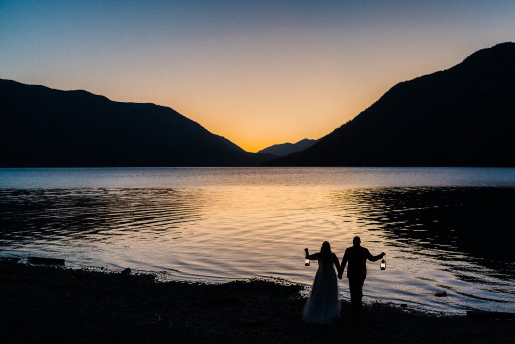 silhouette of couple holding lanterns in during Lake Crescent Elopement