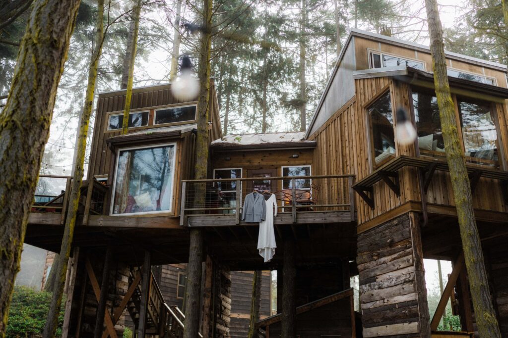 a suit and a dress hanging from a treehouse vacation rental for a Olympic National Park Elopement
