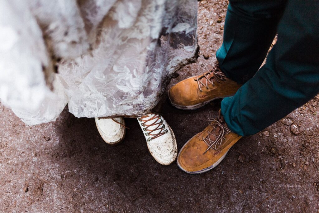 couple wearing hiking boots in wedding attire. 