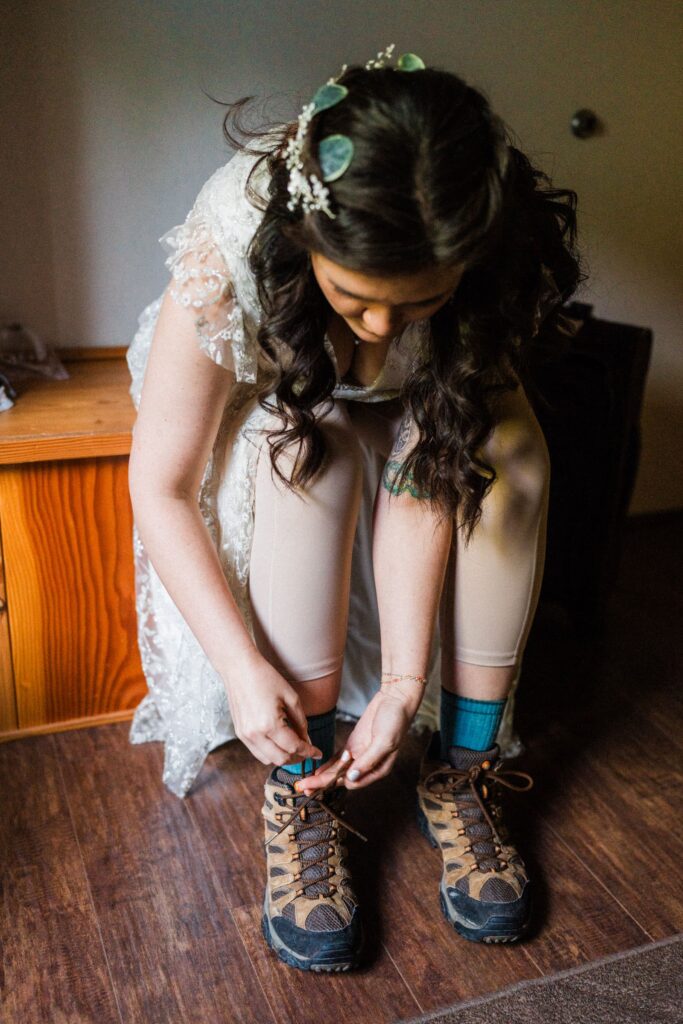 bride putting on hiking boots in her cabin