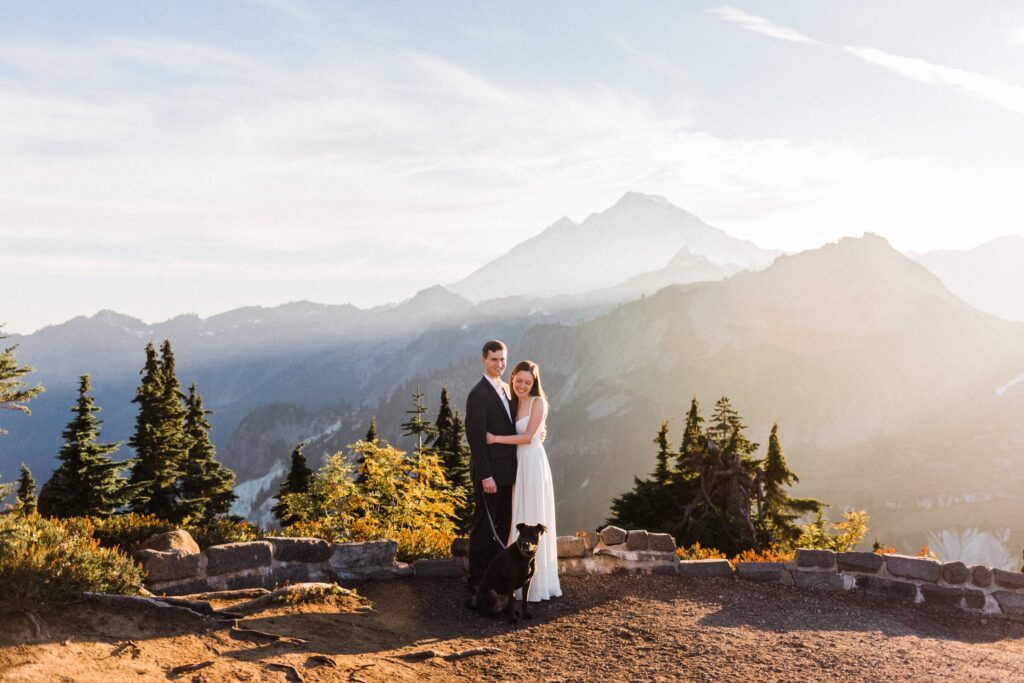 a couple and their dog enjoying the sun rays at their Artist Point Elopement with Mount Baker in the background