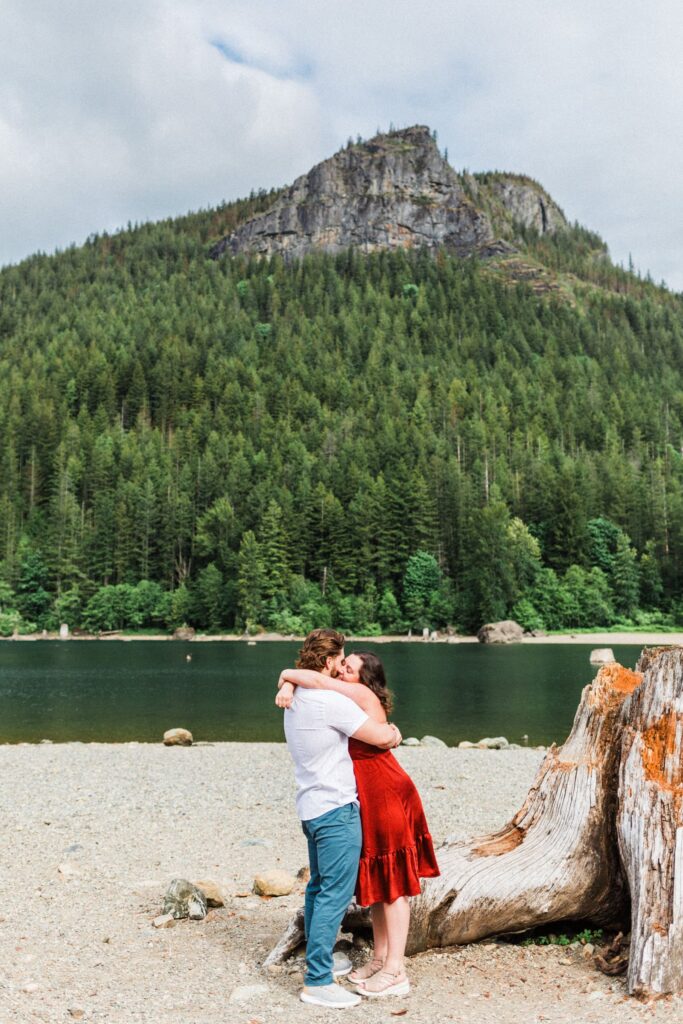 an engaged couple embracing in front of Rattlesnake Ledge.